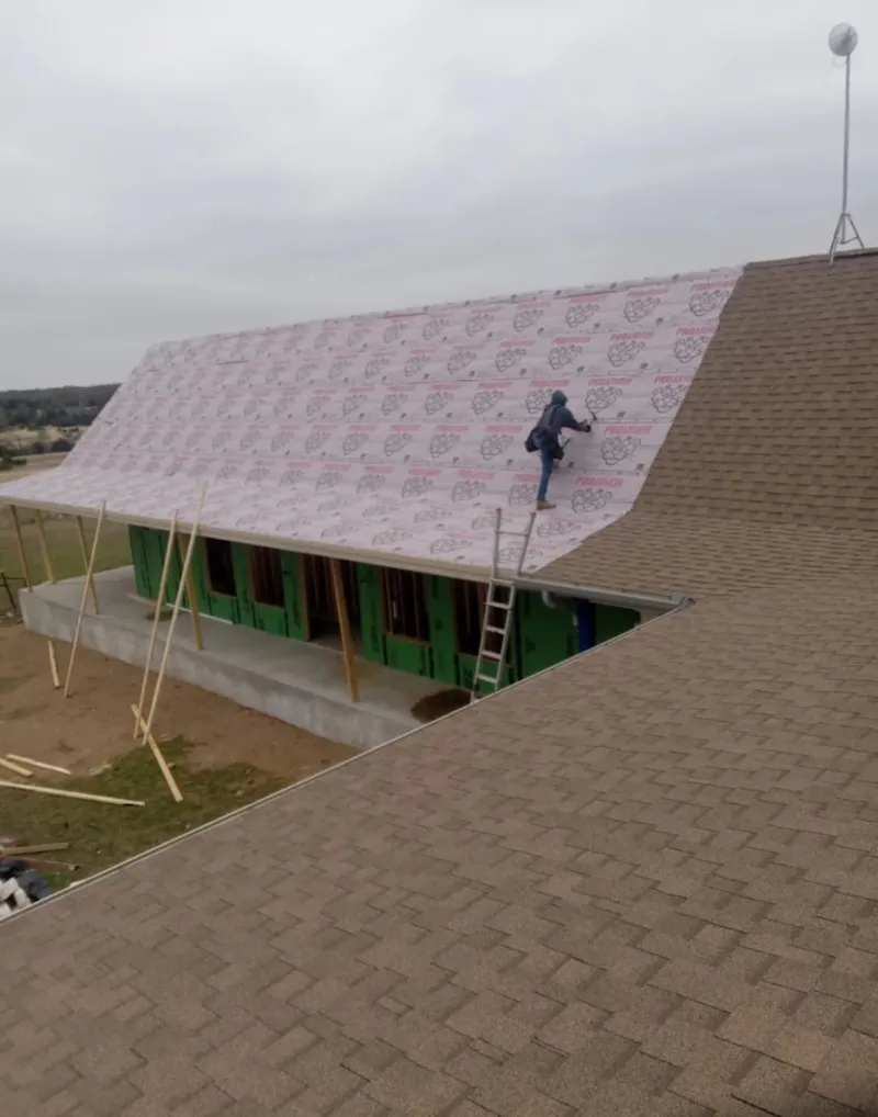 Worker preparing underlayment for a metal roof installation in Bladensburg